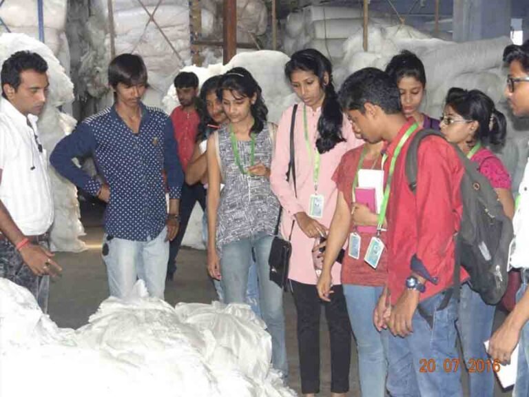 Fashion design students observing fabric testing lab on academic tour